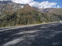 the road has no cars along the sides of the mountains on either side is a highway