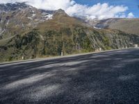 the road has no cars along the sides of the mountains on either side is a highway