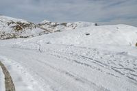 someone wearing skis on the snowy ground of their ski slope covered with snow next to the mountain