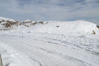 someone wearing skis on the snowy ground of their ski slope covered with snow next to the mountain