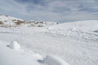 someone wearing skis on the snowy ground of their ski slope covered with snow next to the mountain