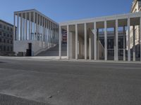 the entrance to a building with a lot of columns on each side of it and steps up to one