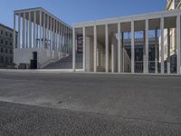 the entrance to a building with a lot of columns on each side of it and steps up to one