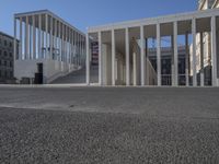 the entrance to a building with a lot of columns on each side of it and steps up to one