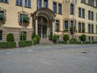 large yellow building with some plants and bushes in front of it for decoration or entertainment