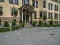 large yellow building with some plants and bushes in front of it for decoration or entertainment