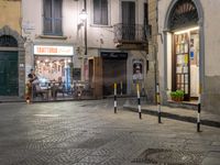 a person walking in a sidewalk at night in an urban area with cobblestones