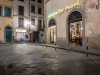 a person walking in a sidewalk at night in an urban area with cobblestones