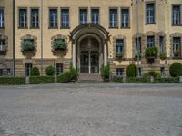 large yellow building with some plants and bushes in front of it for decoration or entertainment