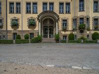 large yellow building with some plants and bushes in front of it for decoration or entertainment