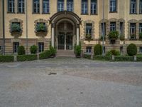 large yellow building with some plants and bushes in front of it for decoration or entertainment