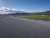 the green road and orange and white stripe line at an event near the racetrack and stadium