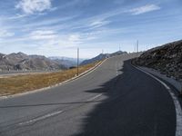 a deserted road leads to mountains in the distance and blue sky is visible in the distance