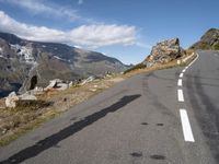 a man on a skateboard is riding on the road and mountain on the other side