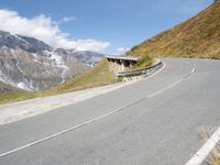 a motorcycle parked on a country road near snow - capped mountains with snowcapped summits