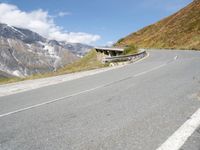 a motorcycle parked on a country road near snow - capped mountains with snowcapped summits