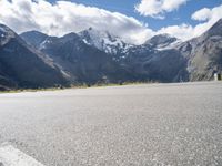 a person is on their cell phone and is running on an asphalt surface with a mountain range in the background