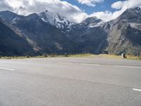 a person is on their cell phone and is running on an asphalt surface with a mountain range in the background
