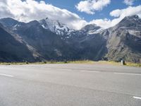 a person is on their cell phone and is running on an asphalt surface with a mountain range in the background