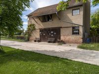 a brick and cement building sitting on the side of a road next to a green grass field