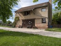 a brick and cement building sitting on the side of a road next to a green grass field