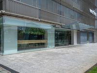 this is an outside view of some glass building near a street way and grass in the foreground