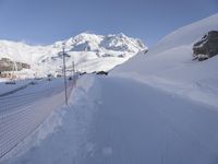 the snow is white and covering the ground and mountainside in a city street area