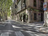 a city street with no traffic and people crossing the street in the distance of the sidewalk