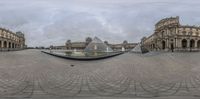 the view of a huge building and a fountain in front of it from a 360 - lens