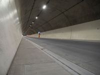 a long grey tunnel with a red and blue fire hydrant on the right side