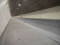 a long grey tunnel with a red and blue fire hydrant on the right side