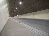 a long grey tunnel with a red and blue fire hydrant on the right side