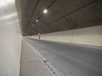 a long grey tunnel with a red and blue fire hydrant on the right side