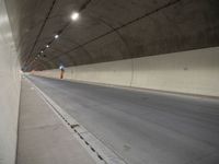 a long grey tunnel with a red and blue fire hydrant on the right side