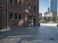 a walkway next to a brick building with a light pole and clock mounted on it