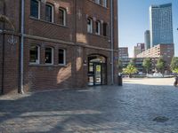 a walkway next to a brick building with a light pole and clock mounted on it