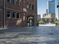 a walkway next to a brick building with a light pole and clock mounted on it