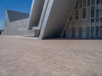 a white building with several steps and large glass panels in the facade is a mosaic that depicts a man