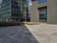 a paved area with several buildings in the background with a large shadow on it's wall