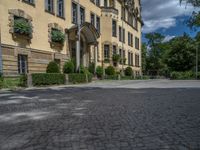 large yellow building with some plants and bushes in front of it for decoration or entertainment