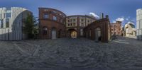 some buildings and rocks are featured in the 360 eye pano shot of the road