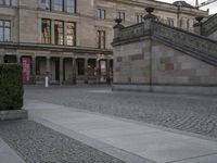 this photo is taken outside a large building with two stairs and three steps leading up to an entry way