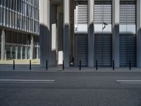 the empty street with bicycles parked in front of the buildings has a sign that says the library on it