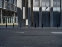 the empty street with bicycles parked in front of the buildings has a sign that says the library on it