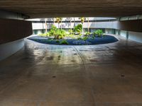 a parking garage with a circular parking area in the center with lots of plants growing on it