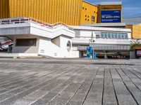 a white building that has a sign at the top of it with a small car