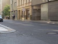 a couple of cars are on the side of a road near some buildings in europe