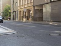 a couple of cars are on the side of a road near some buildings in europe