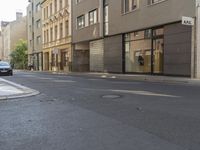 a couple of cars are on the side of a road near some buildings in europe