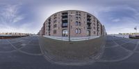 fish eye view of a city street with many buildings around the intersection with several cobbles